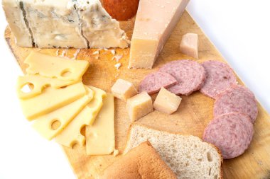 Ekmek ve ahşap tahtanın üzerinde sosis olan peynirin çeşitli türlerinin üst görüntüsü