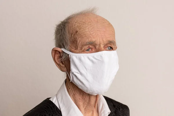 Kranker alter Mann mit medizinischer Gesichtsmaske Porträt in Nahaufnahme veranschaulicht pandemische Coronavirus-Krankheit auf weißem Hintergrund. — Stockfoto