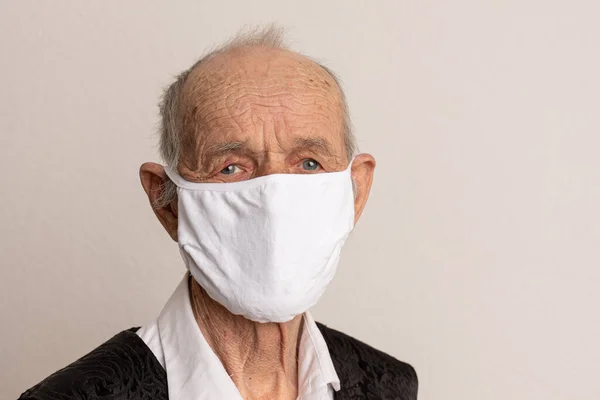 Porträt eines alten Mannes, 80 Jahre alt, mit medizinischer Maske. Ein Konzept zur Gefahr des Coronavirus für ältere Menschen. — Stockfoto