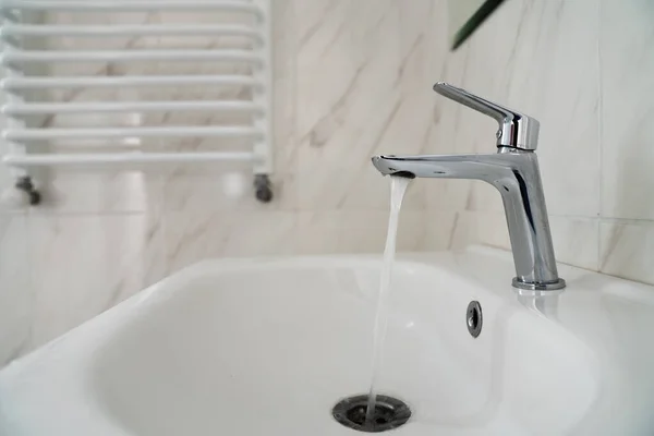 Water stroomt uit de kraan met spoelbak. Het water loopt niet. Watertekort. — Stockfoto