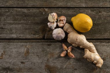 Sarımsak, limon, zencefil, ahşap arka planda soğuk algınlığına iyi gelir.