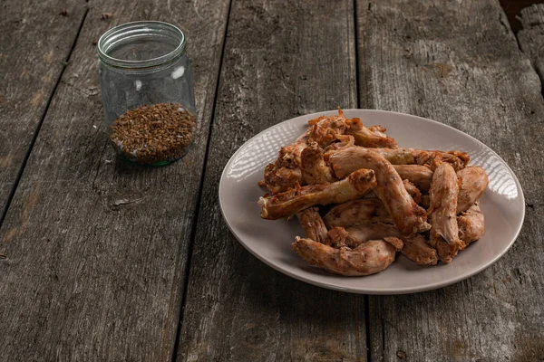 Buckwheat in jar and fries chicken necks on the plate — Stock Photo, Image