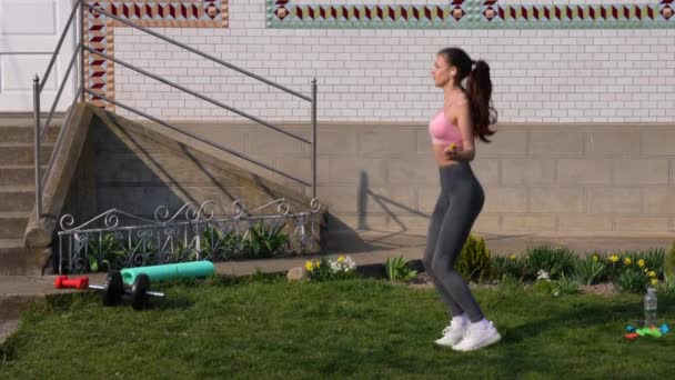 Fitness, sport, allenamento, parco e stile di vita: una donna europea sorridente che si allena con la corda da salto all'aperto a casa — Video Stock