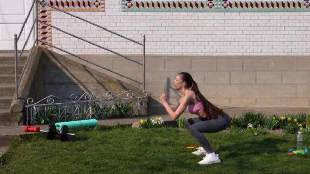 ヒットワークアウトジャンプスクワット演習で女性のトレーニング脚にフィットします。自宅で屋外で心臓運動を行うフィットネストレーニング爆発的なジャンプや電球を活性化するために接着剤. — ストック動画