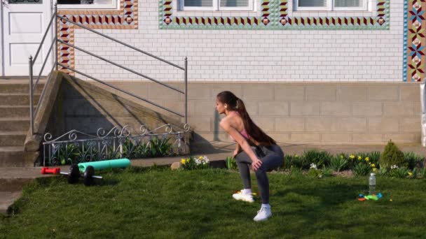 Junge attraktive und schöne hispanische Sportlerin in Sportbekleidung, die ihren Körper dehnt, Frau macht Beweglichkeitsübungen, um sich vor dem Laufen aufzuwärmen — Stockvideo