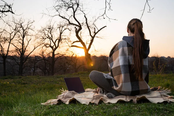 Ordinateur portable sur plaid, fille regardant coucher de soleil freelance dans la nature . — Photo
