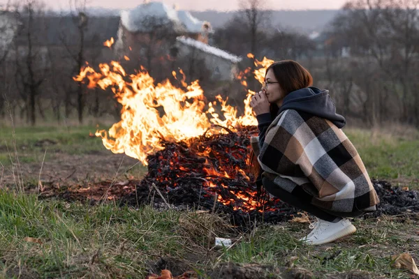 Menina morena atraente em óculos descansando perto do fogo — Fotografia de Stock