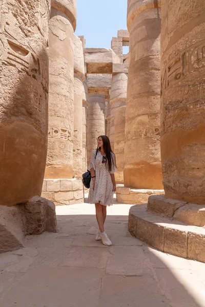Genç ve güzel bir kadın, Mısır 'ın Luxor kentindeki Karnaks tapınağının sütunları arasında fotoğraf çekiyor..