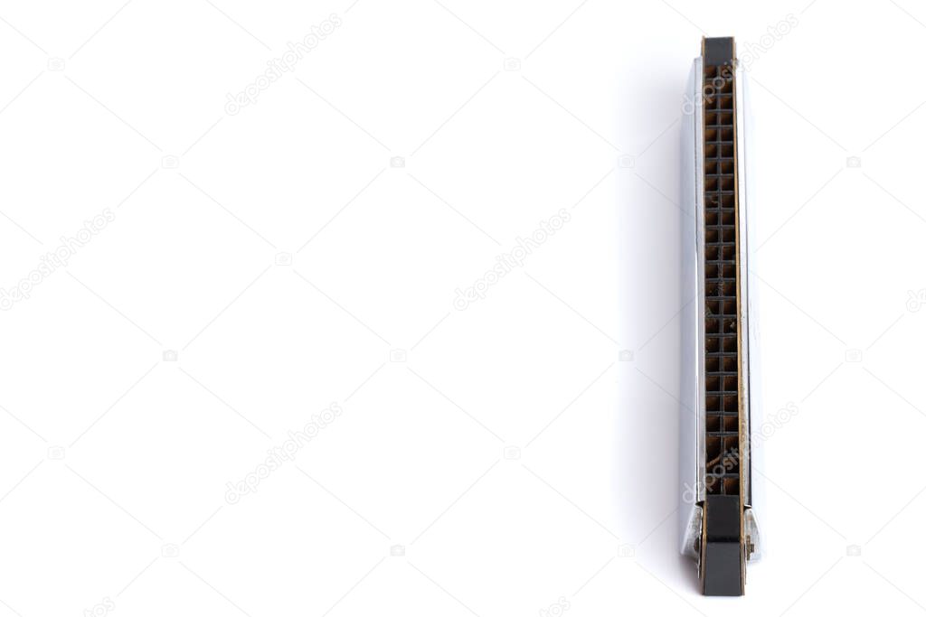 Used small harmonica made from steel and plastic, isolated on white