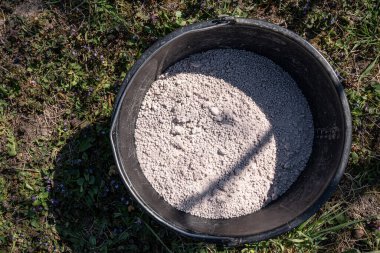 Bahçesinde organik gübre olan plastik bir kova..