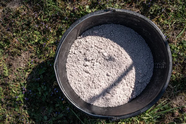 Bahçesinde organik gübre olan plastik bir kova..