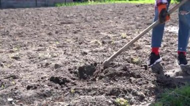 Kot pantolonlu genç bir kız. Toprakla batmış. Çapalı bir delik.