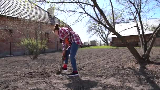 Lebensstil einer europäischen Landfrau, die im Hinterhof Erde schaufelt — Stockvideo