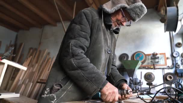 Grand-père en vieux vêtements attache le foreur à la perceuse — Video