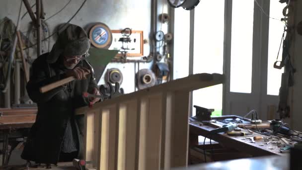 Συγκεντρωμένος παλαιός ξυλουργός που κατασκευάζει ξύλινη σκάλα στο οικιακό του εργαστήριο — Αρχείο Βίντεο