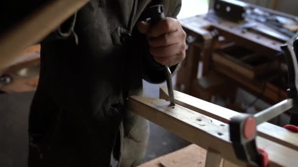 Primer plano de las manos de un carpintero que trabaja con un cincel y herramientas de talla — Vídeo de stock