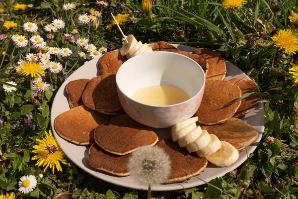 Belo verão acolhedor ou piquenique de primavera com panquecas, mel e banana — Fotografia de Stock