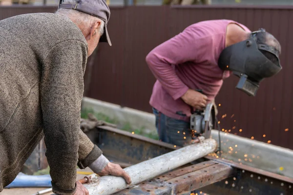 Technik řezání kovů, technici používají nástroje řezání vláken k řezání oceli pro stavbu. — Stock fotografie