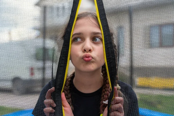 Linda chica se asoma a la red negra y el envío de aire beso — Foto de Stock