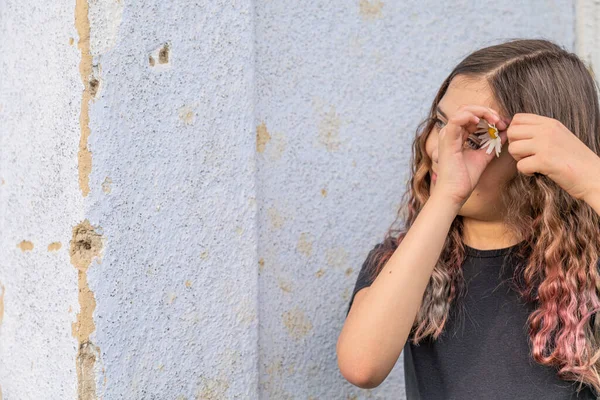 Morena adolescente chica pone en su pelo diente de león flor — Foto de Stock