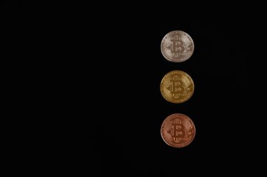 Telif uzayı ile siyah arkaplan üzerinde izole edilmiş üç bitcoin madeni para hattı