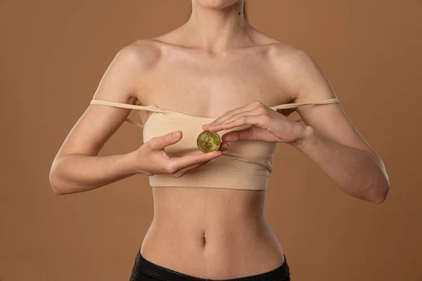 一个穿着米色胸罩、赤身裸体、手里拿着金币的年轻女性的剪影 — 图库照片