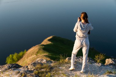 Kameralı genç bir kadın fotoğraf çekiyor. Blogger photoshoot konsepti. Turist seyahatleri