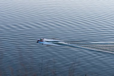 Kırmızı uçaklı şişme motorlu tekne. Suyun üzerinde yüzüyor. Güneşli bir yaz gününde ırmakta.