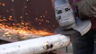 Dairesel testere ile metal bir boruyu kesmek, bir sürü kıvılcım.