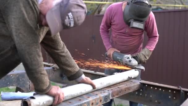 Zware industrie werknemer snijden stalen buis met haakse slijper in de werkplaats — Stockvideo