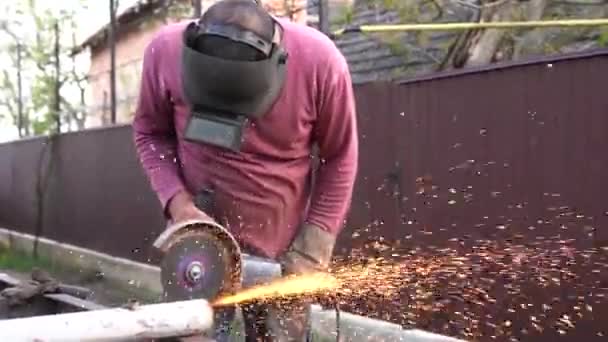 Heavy industry worker cutting steel with angle grinder — Stock Video