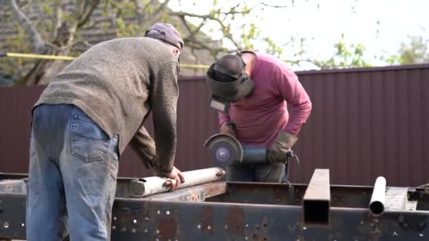 Staal verwerkende fabriek, ambachtsman en zijn leerling die samenwerken — Stockvideo