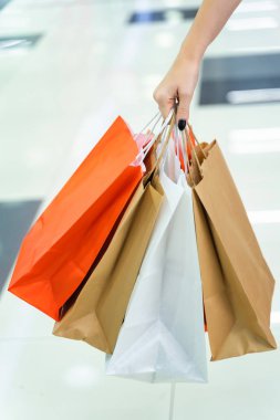 Süpermarkalı bir kızın elinde, içinde alışveriş olan kağıt torbalar.