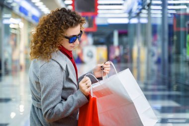 Güzel, seksi bir manken alışveriş merkezinde oturur ve onu muayene eder.