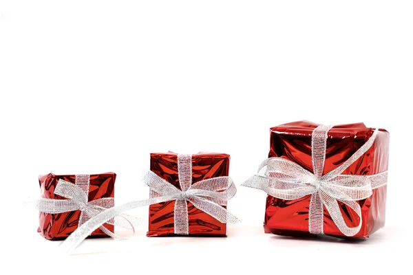 Όμορφα δώρα σε κόκκινο γυαλιστερό χαρτί με ασημί φιόγκους σε λευκό β — Φωτογραφία Αρχείου