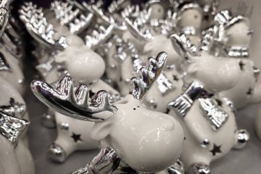 Bir markette rafta duran porselen beyaz ve gümüş geyik.