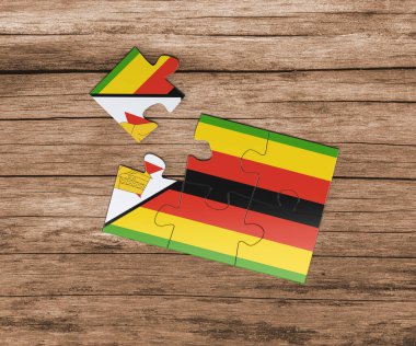 Yapboz üzerinde Zimbabwe ulusal bayrağı. Bir parçası eksik. Tehlike kavramı.