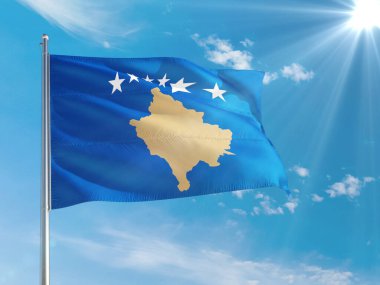 Derin mavi gökyüzüne karşı rüzgarda dalgalanan Kosova ulusal bayrağı. Kaliteli kumaş. Uluslararası ilişkiler kavramı.