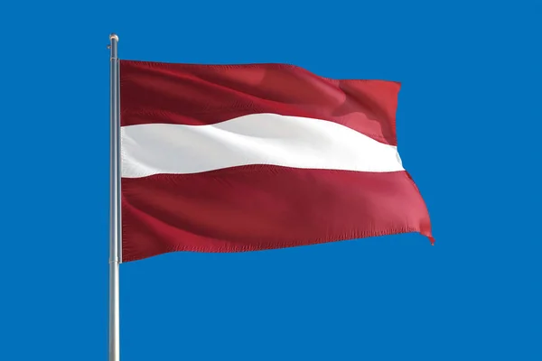 stock image Latvia national flag waving in the wind on a deep blue sky. High quality fabric. International relations concept.