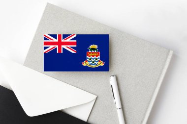 Cayman Islands flag on minimalist letter background. National invitation envelope with white pen and notebook. Communication concept. clipart