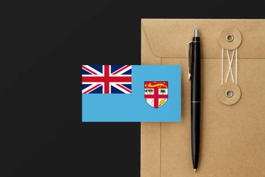 Mektup ve siyah kalem arkaplanda Fiji bayrağı var. Ulusal davet konsepti. Eğitim teması için davet.