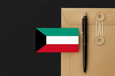 Mektup ve siyah kalem arkaplanda Kuveyt bayrağı. Ulusal davet konsepti. Eğitim teması için davet.