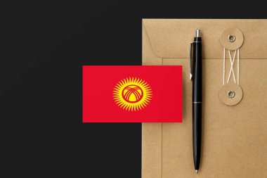 Kırgızistan bayrağı zarf ve siyah kalem arkaplanda. Ulusal davet konsepti. Eğitim teması için davet.