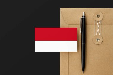 Mektup ve siyah kalem arkaplanda Monako bayrağı. Ulusal davet konsepti. Eğitim teması için davet.