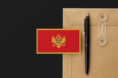 Karadağ, zarf mektubu ve siyah kalem geçmişi üzerinde bayrak salladı. Ulusal davet konsepti. Eğitim teması için davet.