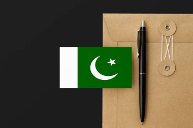 Mektup ve siyah kalem arkaplanda Pakistan bayrağı. Ulusal davet konsepti. Eğitim teması için davet.