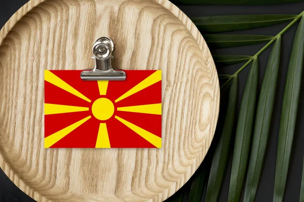 マケドニアの旗は木製の板にタグ付けされた 熱帯のヤシは背景にモンスターを残します 最小限の国家概念 — ストック写真