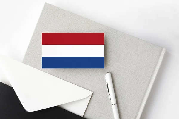 Flaga Holandii Minimalistycznym Tle Literowym Narodowa Koperta Białym Długopisem Notatnikiem — Zdjęcie stockowe
