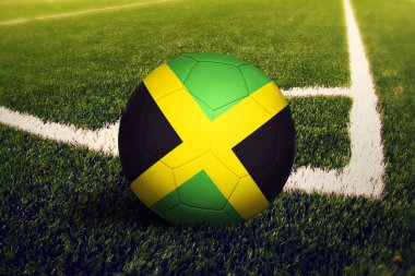 Jamaika bayrağı köşe vuruşu pozisyonunda, futbol sahasında. Ulusal futbol teması yeşil çimlerde.