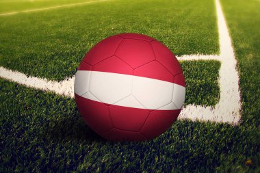 Letonya bayrağı köşe vuruşu pozisyonunda, futbol sahasında. Ulusal futbol teması yeşil çimlerde.